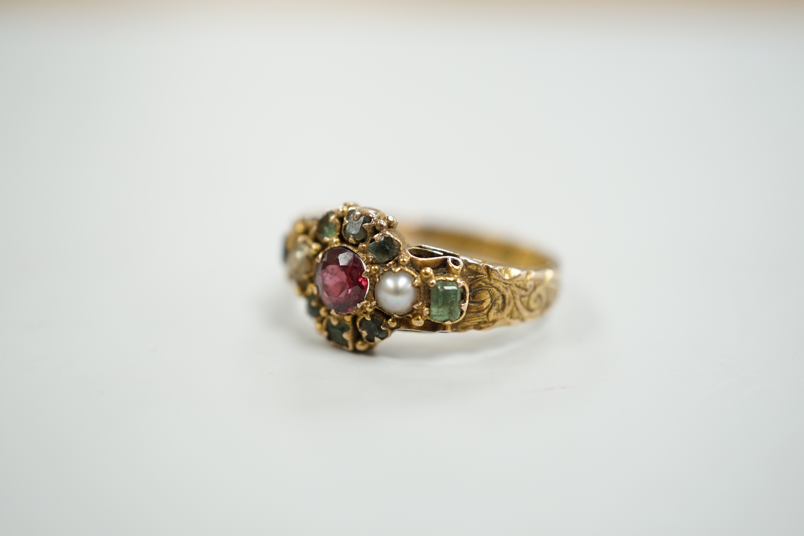 A late Victorian 15ct gold, ruby?, emerald and seed pearl cluster set dress ring, size K, gross weight 2.6 grams, with engraved shank.
